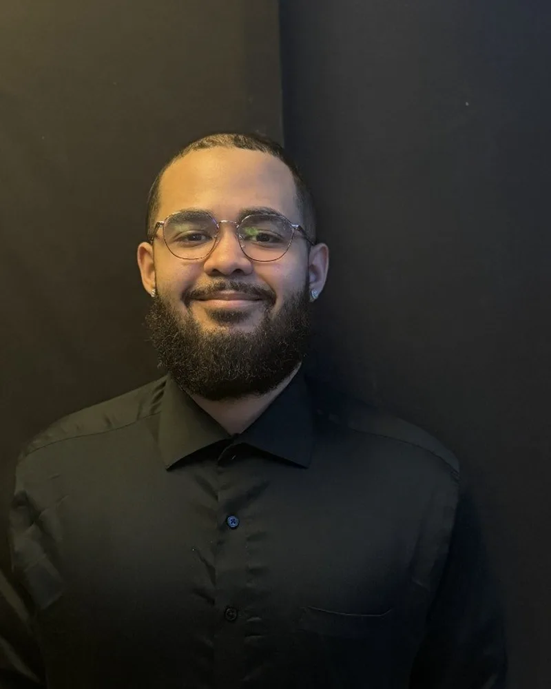 Javi Matos Rodriguez in a black shirt against a dark backdrop.