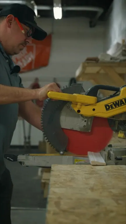 A Prop Ready carpenter cutting a board on a miter saw.